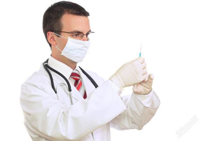 врач держит в руках шприц с раствором
